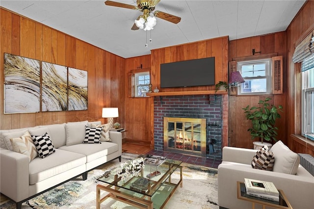 living room with wood walls, a fireplace, and a wealth of natural light