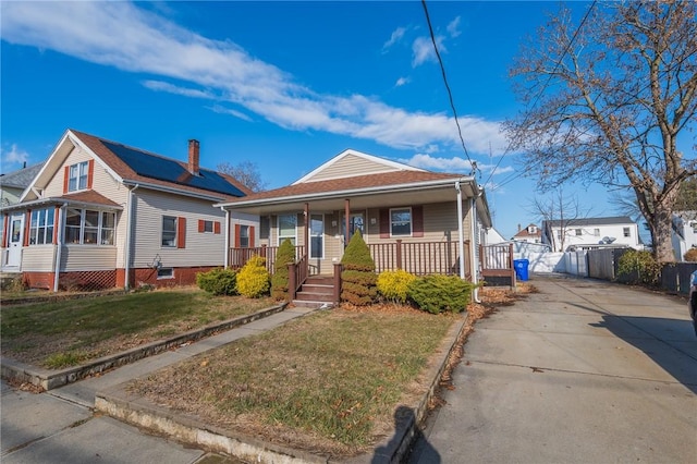 bungalow-style house with covered porch and a front lawn