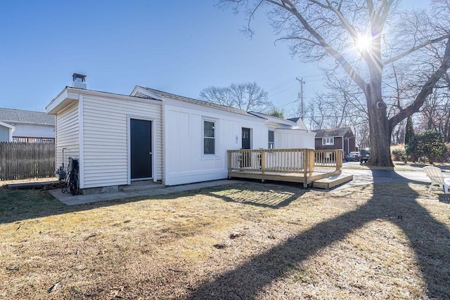 back of property with a lawn and a wooden deck