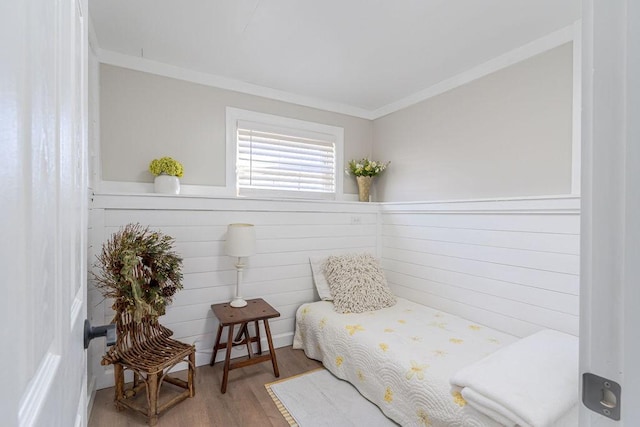 bedroom with crown molding, hardwood / wood-style floors, and wooden walls