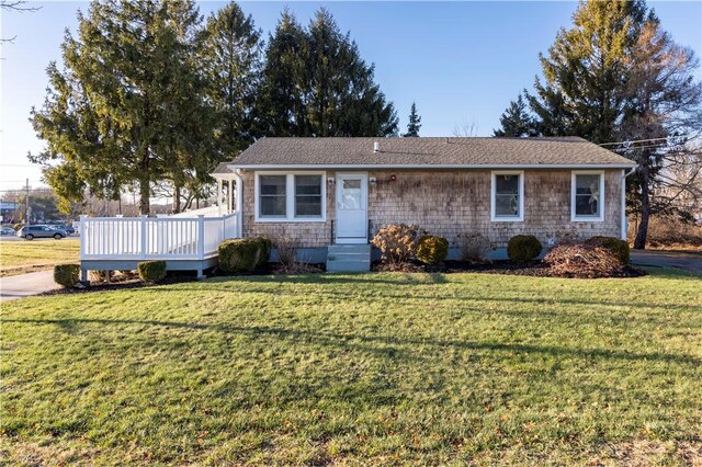 ranch-style home featuring a deck and a front lawn