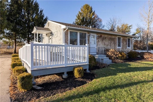 view of front of home with a wooden deck and a front lawn