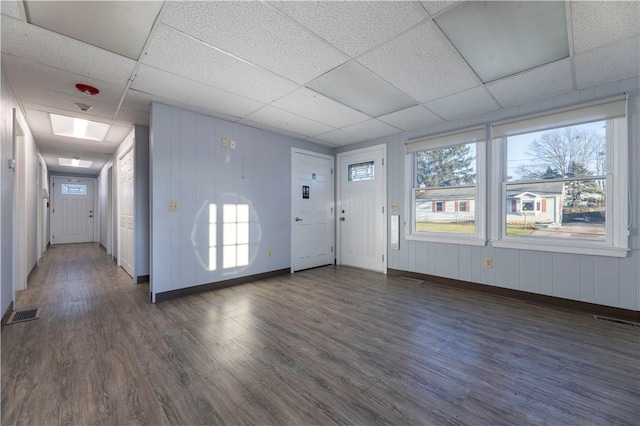 interior space with a drop ceiling and dark wood-type flooring