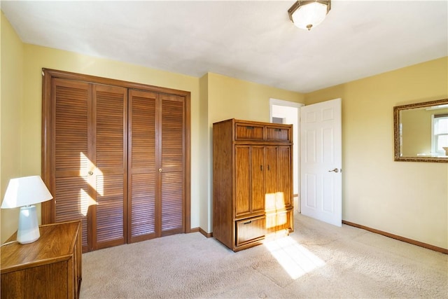 unfurnished bedroom with light colored carpet and a closet