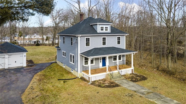 country-style home featuring a porch, a garage, an outbuilding, and a front lawn