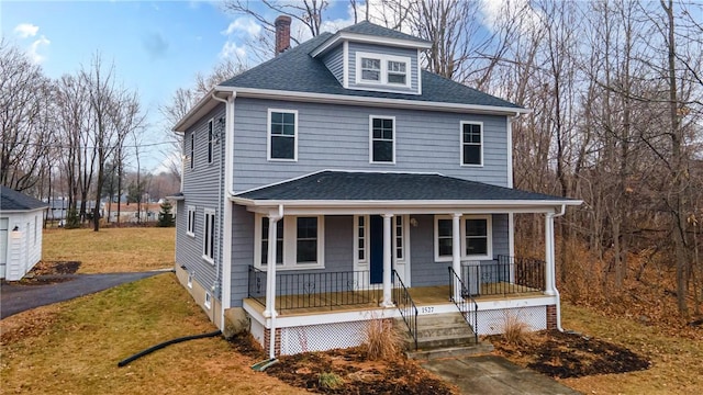 view of property with covered porch and a front lawn