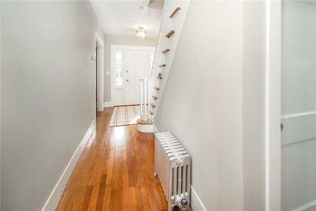 corridor with radiator heating unit and hardwood / wood-style flooring