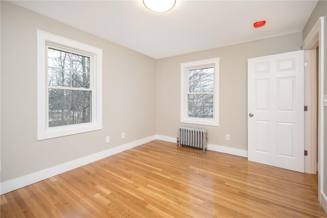 spare room with radiator and light wood-type flooring