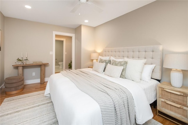 bedroom featuring ceiling fan, light hardwood / wood-style floors, and connected bathroom