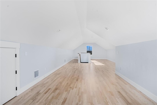 additional living space featuring light hardwood / wood-style floors and lofted ceiling