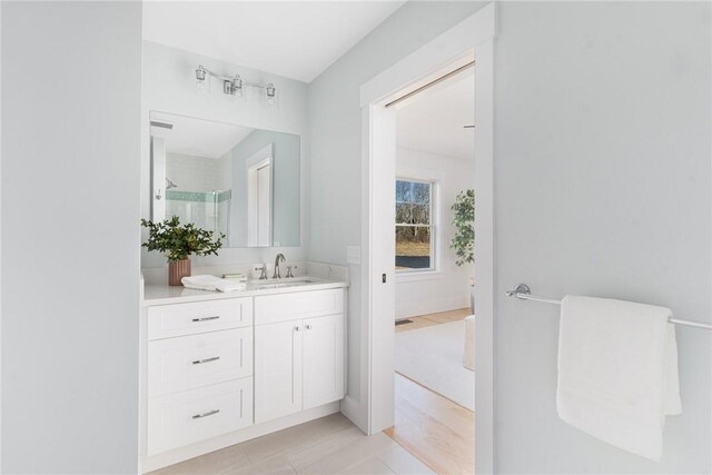 bathroom featuring tile patterned flooring, vanity, and an enclosed shower