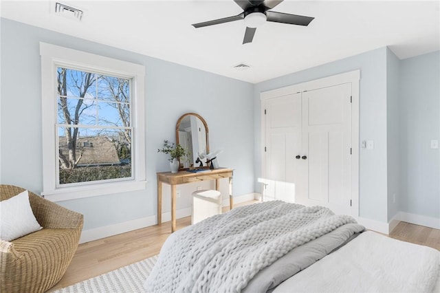 bedroom with ceiling fan, a closet, and light hardwood / wood-style flooring