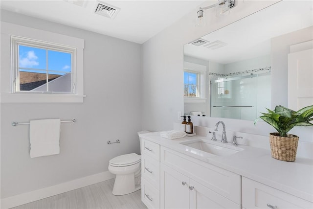 bathroom featuring vanity, toilet, and an enclosed shower