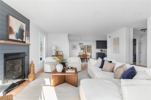 living room with a large fireplace and light wood-type flooring