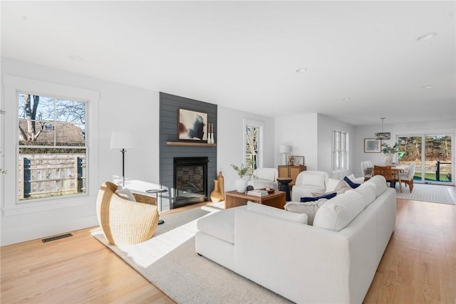 living room with light wood-type flooring and a fireplace