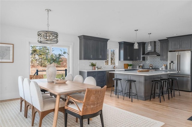 dining room with a wealth of natural light, light hardwood / wood-style flooring, a chandelier, and sink