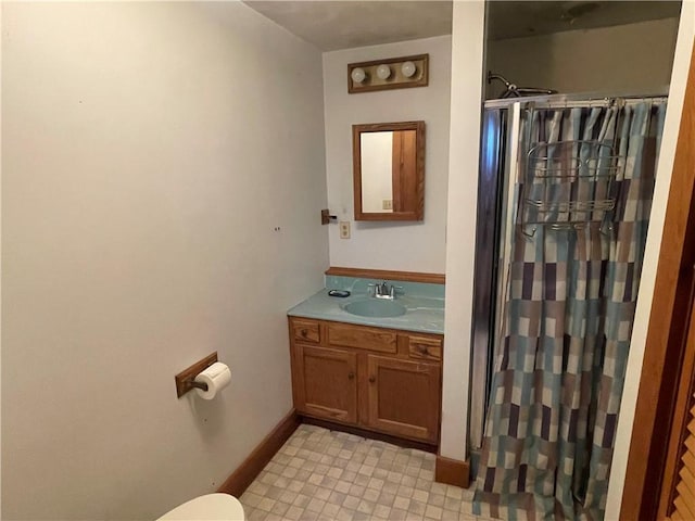 bathroom with curtained shower, vanity, and toilet