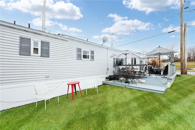 back of house featuring a gazebo, a yard, and a wooden deck