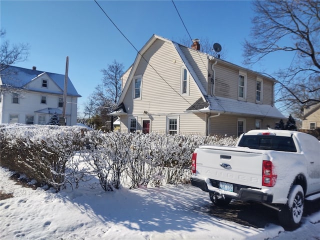 view of snow covered back of property