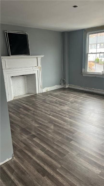 unfurnished living room featuring dark hardwood / wood-style flooring and baseboard heating