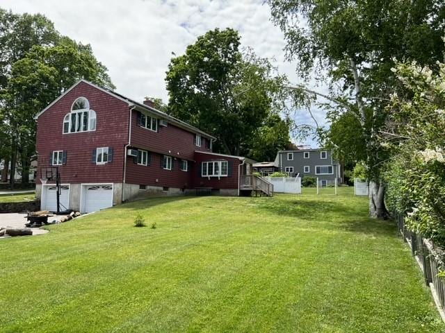 view of yard featuring a garage and a wooden deck