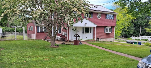 view of front of home featuring solar panels and a front lawn