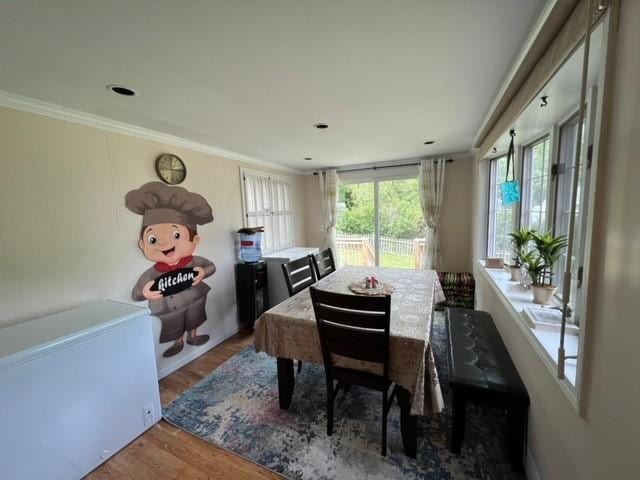 dining space with hardwood / wood-style floors and ornamental molding