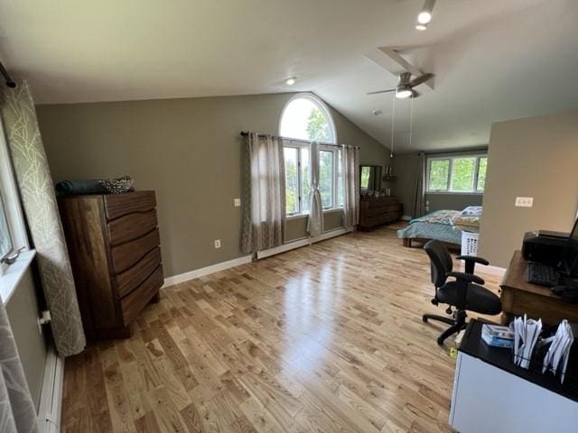 office space with baseboard heating, ceiling fan, light hardwood / wood-style flooring, and vaulted ceiling