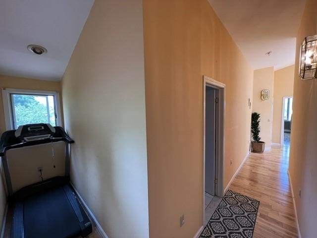 hallway featuring light hardwood / wood-style floors and lofted ceiling