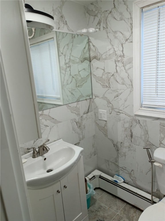 bathroom with vanity, tile patterned floors, toilet, baseboard heating, and tile walls