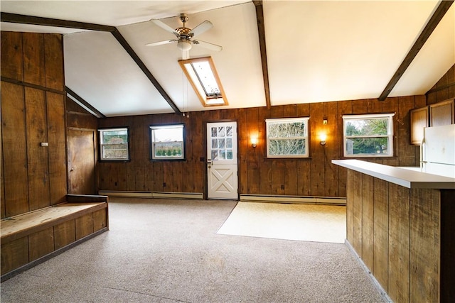 entrance foyer featuring lofted ceiling with skylight, light carpet, and a wealth of natural light