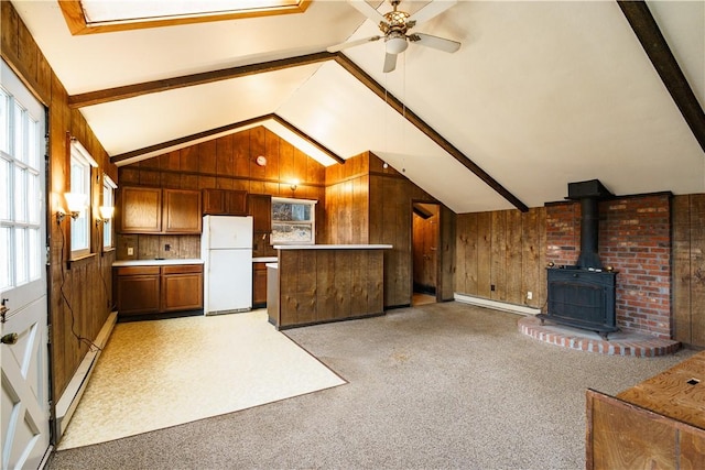 unfurnished living room featuring lofted ceiling with beams, light colored carpet, baseboard heating, and ceiling fan