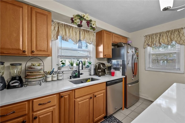 kitchen with sink, light tile patterned floors, and appliances with stainless steel finishes