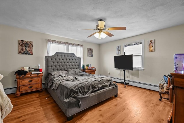 bedroom featuring ceiling fan, baseboard heating, and multiple windows