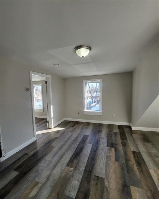 spare room featuring a wealth of natural light and dark hardwood / wood-style flooring