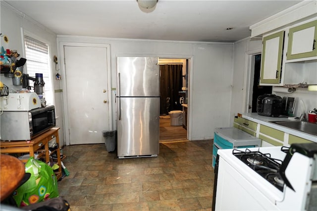 kitchen with stainless steel fridge, white range with gas stovetop, sink, and ornamental molding