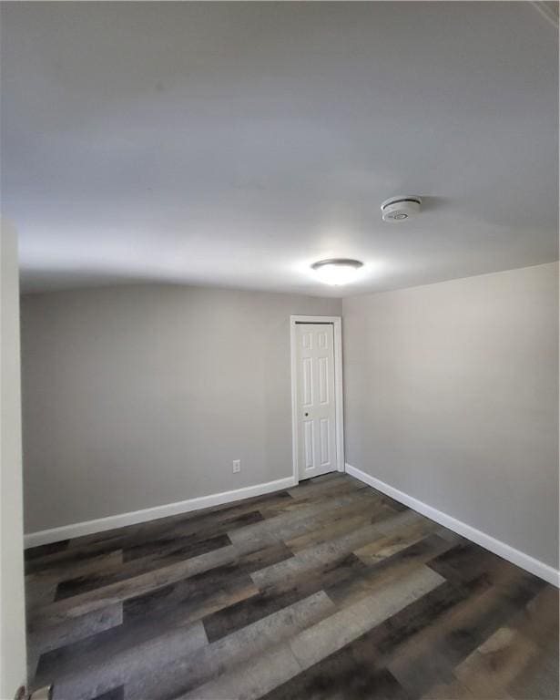 empty room with dark hardwood / wood-style flooring