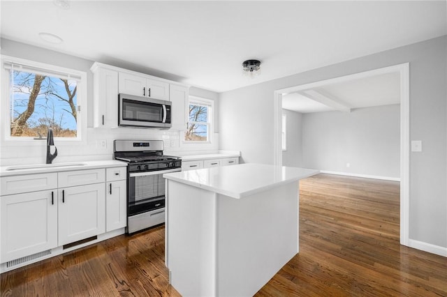 kitchen featuring a center island, dark wood-type flooring, sink, white cabinetry, and stainless steel appliances