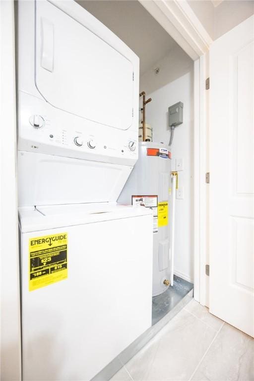 laundry room featuring electric water heater, stacked washing maching and dryer, and light tile patterned flooring