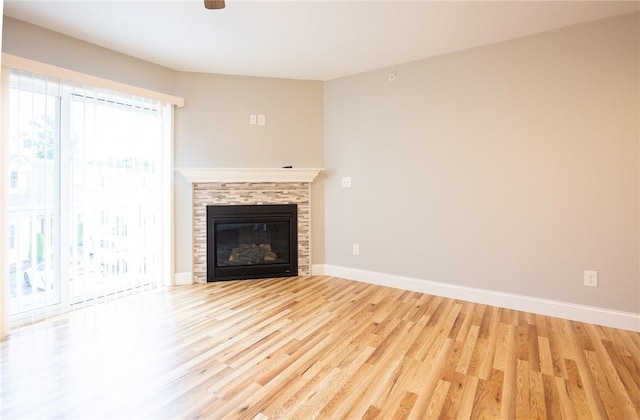 unfurnished living room with a tile fireplace and light hardwood / wood-style flooring