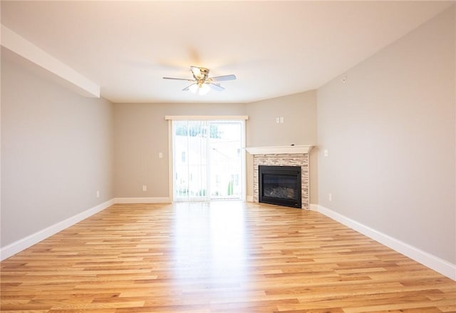 unfurnished living room featuring a fireplace, light hardwood / wood-style flooring, and ceiling fan