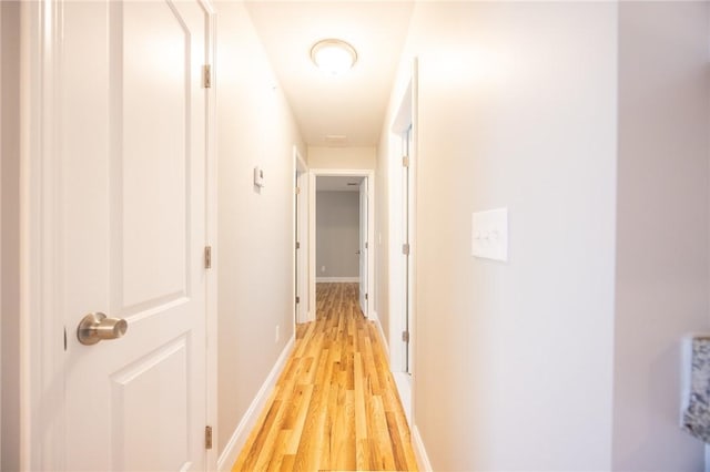 hallway with light hardwood / wood-style floors