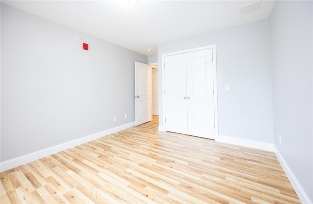 unfurnished bedroom with a closet and light wood-type flooring