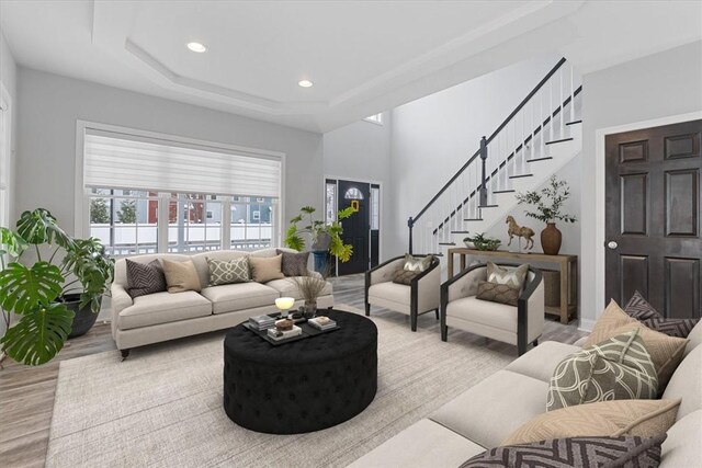 living room with light wood-type flooring and a raised ceiling