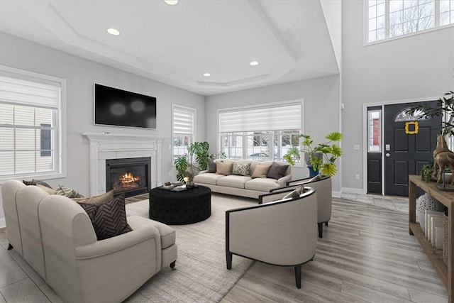 living room featuring light wood-type flooring and a tray ceiling