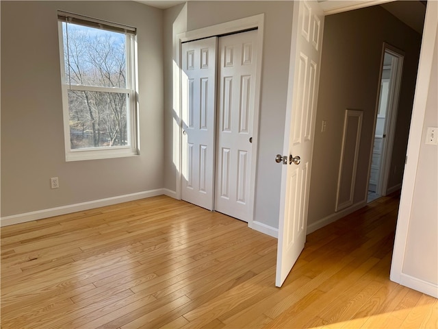 unfurnished bedroom featuring a closet and light hardwood / wood-style flooring