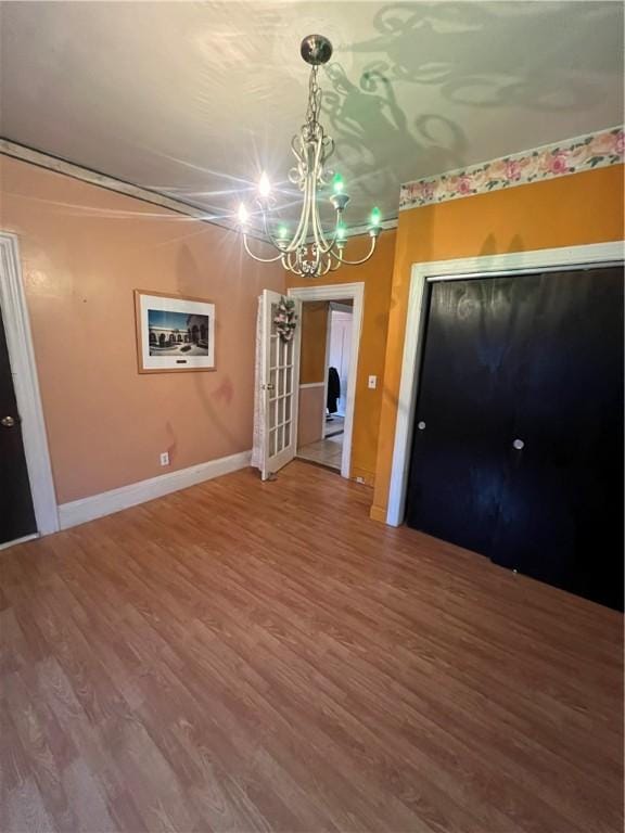 unfurnished dining area with a chandelier and hardwood / wood-style flooring