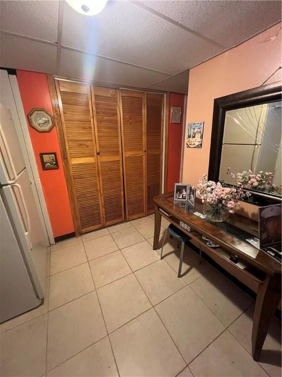 tiled dining space featuring a paneled ceiling