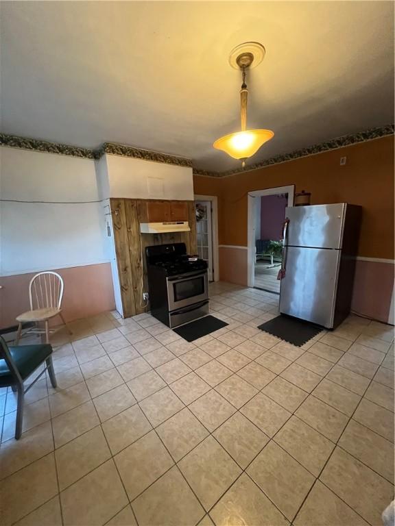 kitchen with stainless steel refrigerator, black range with gas cooktop, and light tile patterned floors