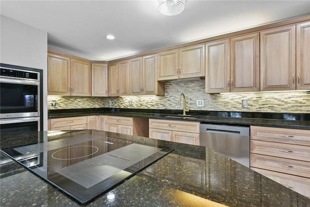 kitchen with decorative backsplash, appliances with stainless steel finishes, dark stone counters, and sink